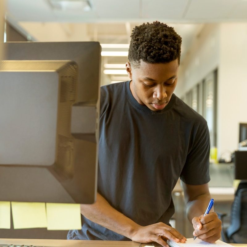 man writing on white paper